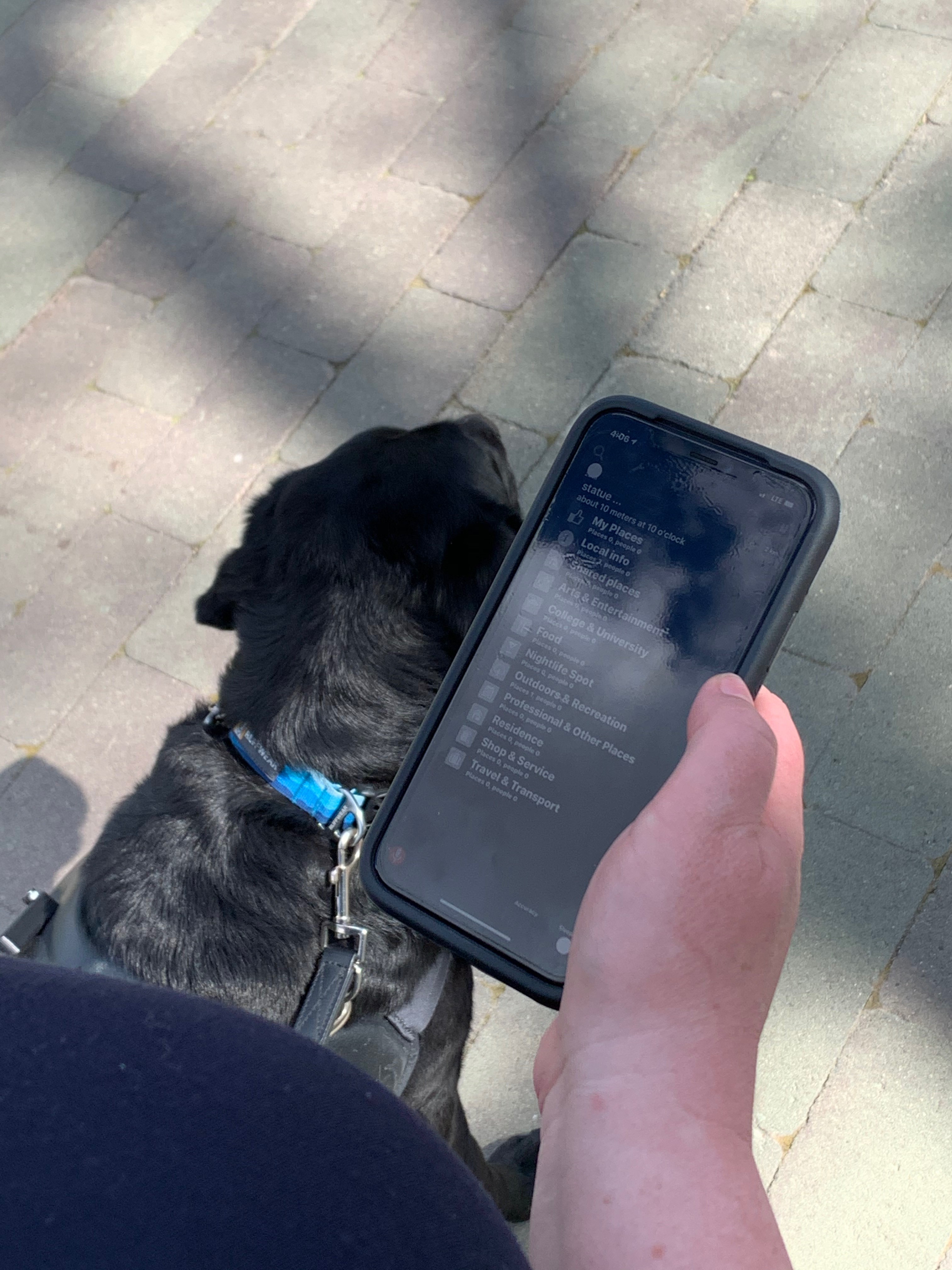 A woman with a guide dog is using the Blindsquare app to navigate Wascana Park.